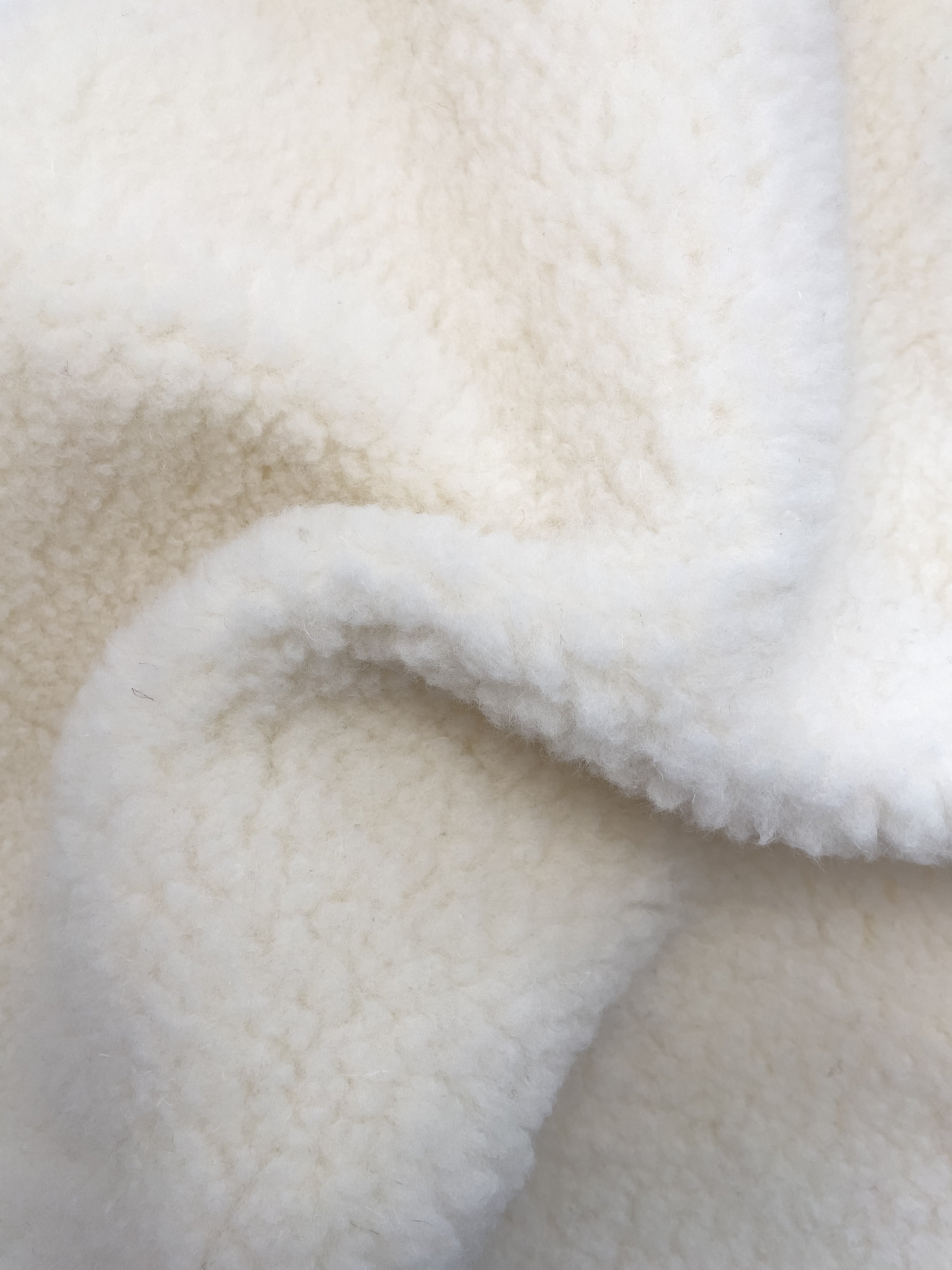 BääBää Fluffi Valkoinen, yksityiskohtainen kuva Fluffin materiaalista– Luonnollinen lampaanvilla huppari, joka tarjoaa mukavuutta ja tyyliä. Hengittävä, lämmin ja mukava päällä.